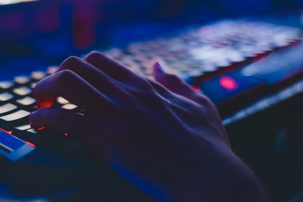 Hacker using a keyboard in a dark room