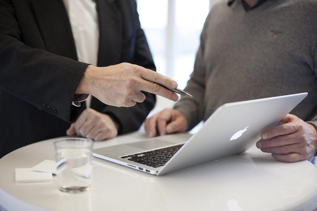 Two people consulting over a laptop