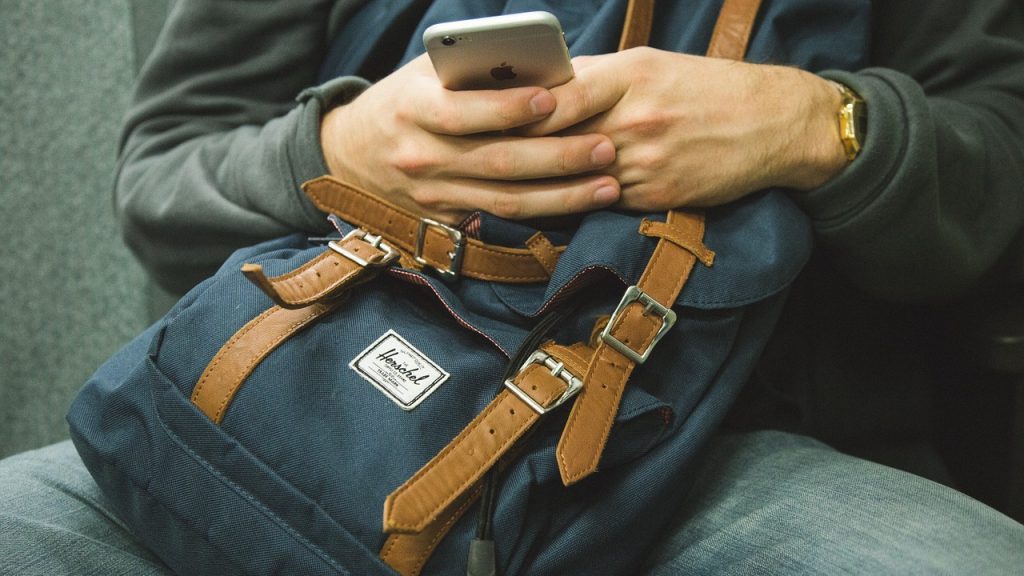 Person traveling with backpack and an iPhone