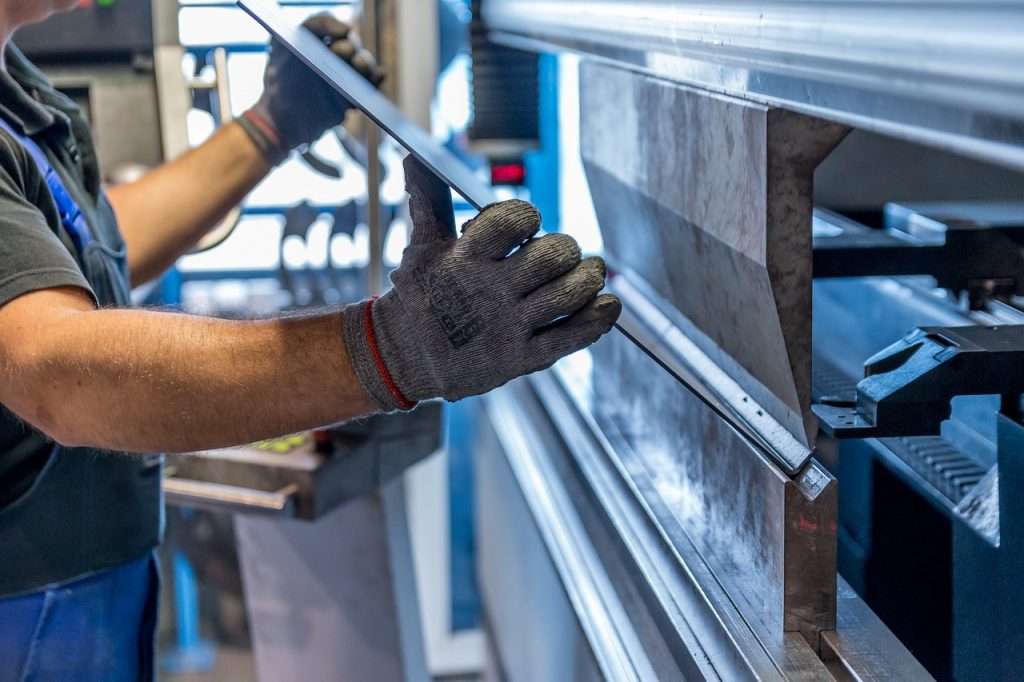 A worker in the manufacturing industry placing material into a machine